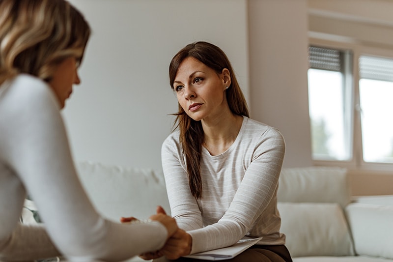 Female psychologist supporting depressed woman.