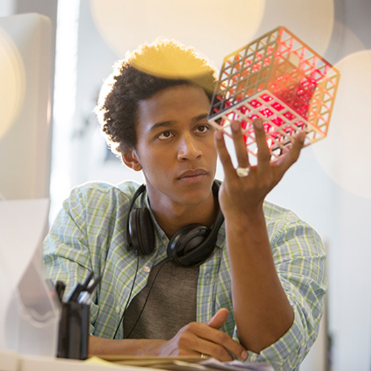 The Concepter, man holding cube, studying it.